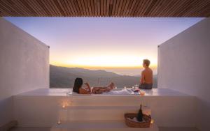 Ein Mann und eine Frau sitzen in einer Badewanne im Sonnenuntergang in der Unterkunft Arroon Chiang Rai, Thailand in Ban San Pu Loei