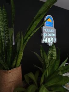 a plant sitting next to a sign that reads potassium dos genus america at Pousada dos Sonhos in Angra dos Reis