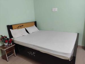 a large bed in a room with a night stand at HOTEL O A.P PALACE in Dīgha