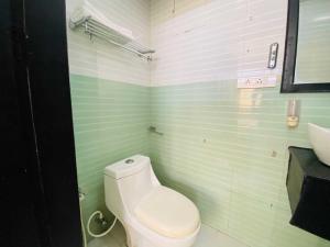 a bathroom with a white toilet and a sink at Hotel O CHOTHY'S PARK in Trippapur +1 photo