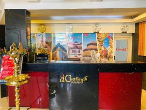 a counter in a restaurant with posters on the wall at Hotel O CHOTHY'S PARK in Trippapur