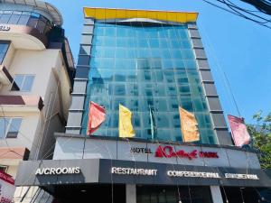 a tall building with flags in front of it at Hotel O CHOTHY'S PARK in Trippapur