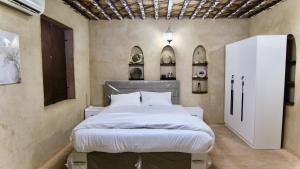 a bedroom with a large bed in a room at Garden House in Al Ḩamrāʼ