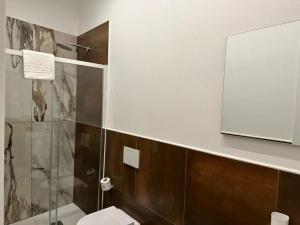 une salle de bain avec toilettes et miroir dans l'établissement Nala & Leo Seaview Apartment, à Lerici