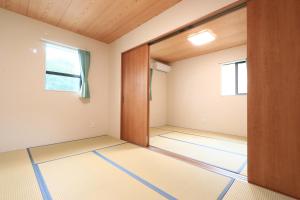 een lege kamer met een deur en een raam bij コテージ鎌倉 in Fujikawaguchiko