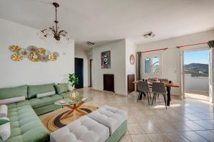 a living room with a green couch and a table at Elysia House in Posidhonía