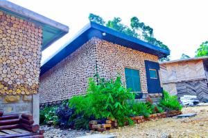 Hakuna Matata Gardens في Migori: مبنى من الطوب وباب ازرق وبعض النباتات