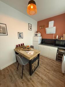 a kitchen with a wooden table and a counter top at Au spa de clem in Guemps