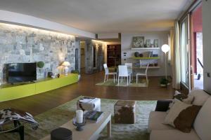 een woonkamer met een bank en een tv bij Paola's Apartment in Belgirate