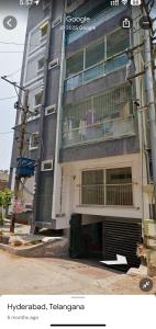 ein hohes Gebäude mit einem Balkon an der Seite in der Unterkunft Emaar Homestays in Hyderabad