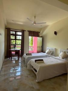 a bedroom with two beds and a table in it at URALSURF HOUSE in Weligama +54 photos