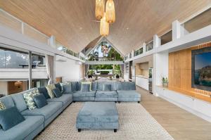 ein Wohnzimmer mit einem blauen Sofa und einem Tisch in der Unterkunft Escape to your dream Samui beach Villa !!! in Ban Na We