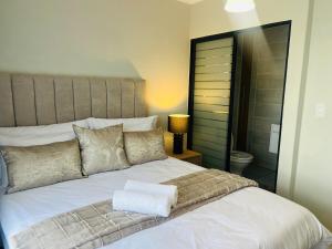 a bedroom with a large white bed and a lamp at 2 Bed at the Blyde in Pretoria +5 photos