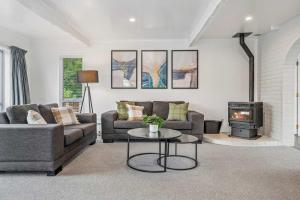 een woonkamer met een bank en een fornuis bij Tihi Time - Great Deck Spa Pool & Games Room in Rotorua