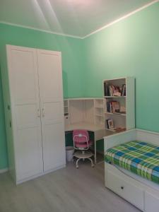 Un dormitorio con una cama, un escritorio y una silla. en La casa del nespolo, en Massa