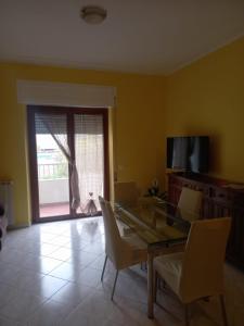 Un comedor con mesa y sillas y una ventana. en La casa del nespolo, en Massa