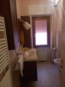 Un baño con lavabo y ventana. en La casa del nespolo, en Massa