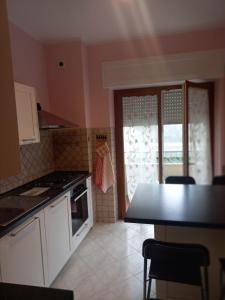 Una cocina con gabinetes blancos y una mesa y una ventana. en La casa del nespolo, en Massa