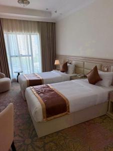 Una habitación de hotel con dos camas y una ventana. en فندق دفلى, en La Meca
