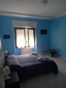 a blue bedroom with a bed and a window at La casa del nespolo in Massa +3 photos