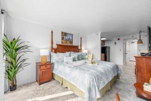 ein Schlafzimmer mit einem großen Bett mit einem hölzernen Kopfteil in der Unterkunft Holiday Pavilion 208 in Myrtle Beach