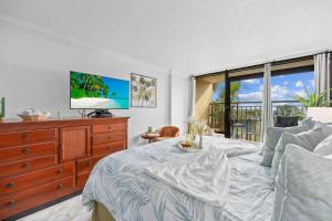 ein Schlafzimmer mit einem Bett und einem Fernseher auf einer Kommode in der Unterkunft Holiday Pavilion 208 in Myrtle Beach + 35 Fotos