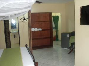 Habitación con dormitorio con cama y vestidor. en Armaan Enclave Diani, en Diani Beach