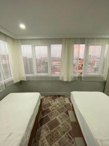 two beds in a room with two windows at Ezel Group Hotel in Antalya
