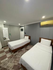 a room with three beds in a hospital room at Ezel Group Hotel in Antalya
