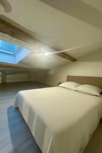a bedroom with a white bed and a window at Charmant studio avec mezzanine - proche de Angoulême in Saint-Saturnin