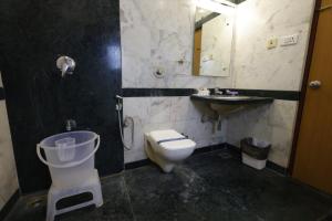 a bathroom with a toilet and a sink and a mirror at Hotel Nahar Manchester Inn in Coimbatore +30 photos
