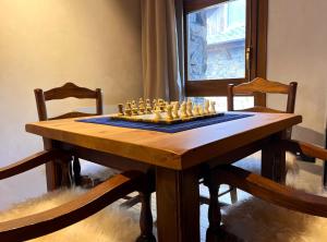 a chess board on a table with two chairs at AC Apartaments Tarter Chalet in El Tarter