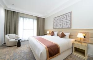 una habitación de hotel con una cama grande y una silla en فندق دفلى, en La Meca