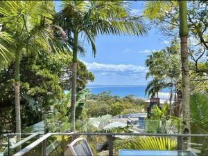 a view of the ocean from a resort with palm trees at Bright Ocean Horizon Escape in Noosa Heads