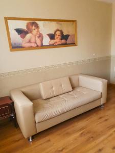 ein weißes Sofa in einem Wohnzimmer mit einem Bild von Engeln in der Unterkunft 2-х комнатная квартира в центре in Qaraghandy