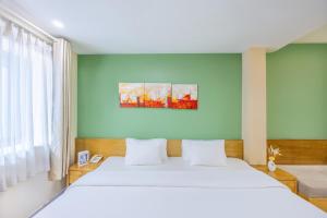 ホーチミン・シティにあるA25 Hotel - 142 Bùi Thị Xuânの白いベッドと青い壁のある寝室