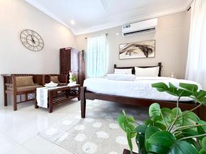 una camera con letto, divano e orologio di STARBURST By The Beach Goa a Benaulim Altre 158 foto