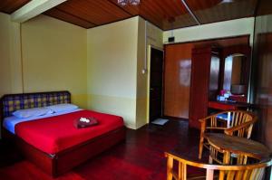 1 dormitorio con 1 cama, mesa y sillas en Flora Bay 2 en Perhentian Island