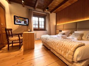 a bedroom with a large bed and a television at AC Apartaments Tarter Chalet in El Tarter +48 photos