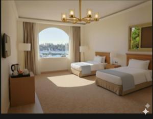 Crystala 2 guest house في أسوان: غرفة فندق بها سريران ونافذة