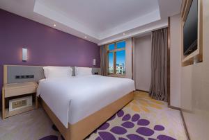 a bedroom with a large white bed and a window at Lavande Hotel Guangzhou Panyu Chimelong Xiajiao Metro Station Branch in Guangzhou