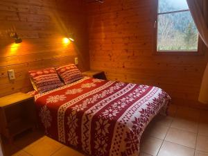 une chambre avec un lit dans une cabane en bois dans l'établissement Chalet au bord du lac Longemer, à La Celle-sous-Gouzon