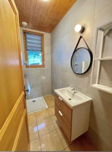 une salle de bain avec un lavabo et un miroir dans l'établissement Chalet au bord du lac Longemer, à La Celle-sous-Gouzon 22 autres photos