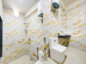a bathroom with a white toilet and a marble wall at Hotel Aero Home in Behror +36 photos