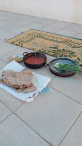 une table avec deux bols de nourriture et de légumes dans l'établissement Halfway motel, à An Namatah