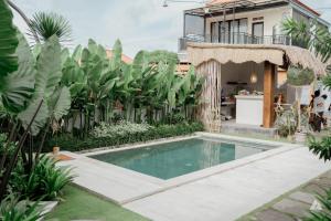 a swimming pool in the backyard of a house at Skutik House in Tanah Lot