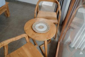 a hat sitting on a wooden table with two chairs at Skutik House in Tanah Lot