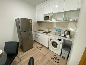 una piccola cucina con frigorifero e lavatrice di The Bay cliff By Tris a Patong Beach