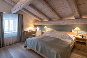 a bedroom with a bed and a desk and a window at Hotel Post in Bivio