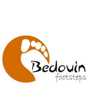 un logo pour un restaurant avec une main tenant une empreinte de pied dans l'établissement Halfway motel, à An Namatah 2 autres photos